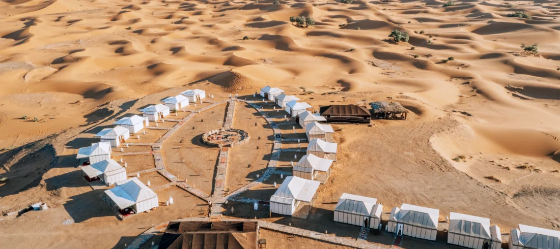 Couple riding a camel during the 4-day program from Marrakech to the Merzouga desert at sunset