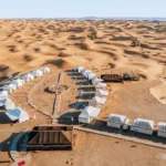 Couple riding a camel during the 4-day program from Marrakech to the Merzouga desert at sunset