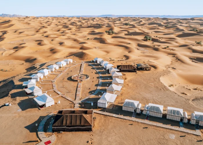 Couple riding a camel during the 4-day program from Marrakech to the Merzouga desert at sunset